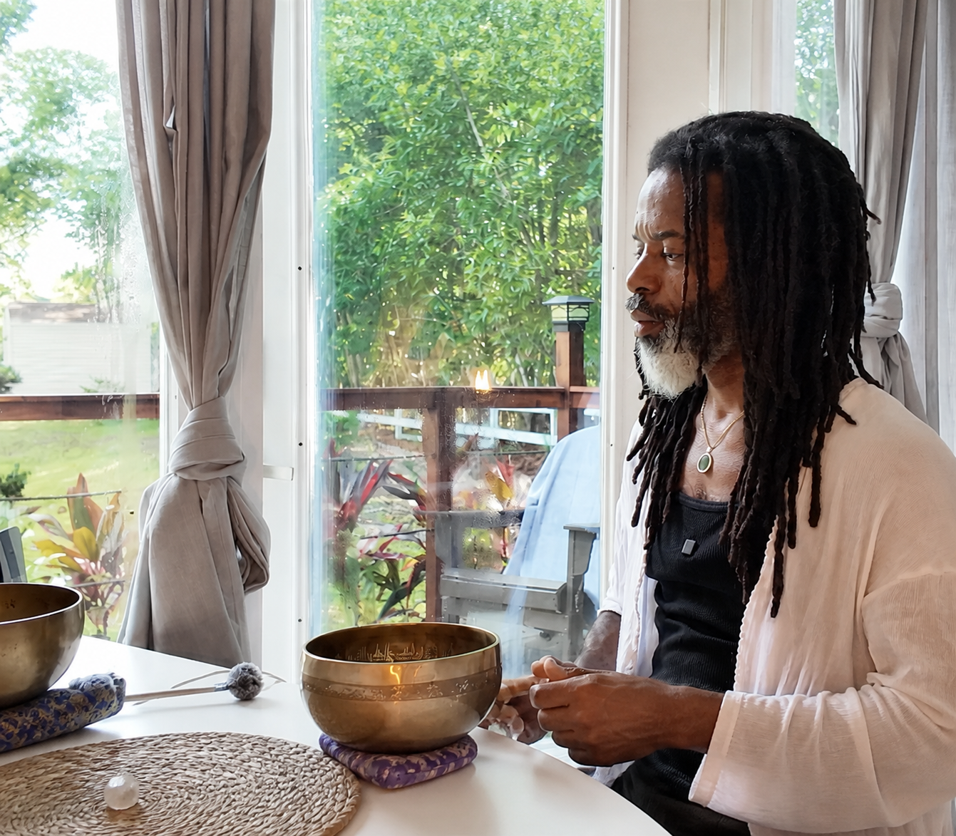 Moses Hill seated with singing bowls in a calm sanctuary